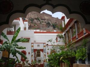 een uitzicht op een gebouw met een berg op de achtergrond bij Krishna Prakash Heritage Haveli in Jodhpur