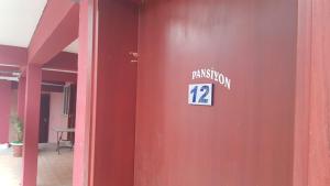 帕莫卡萊的住宿－Karaca Termal Pansiyon，红色的墙,上面有读到的标志