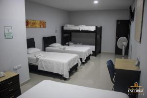 Habitación con 2 camas y escritorio con espejo. en HOTEL ESCORIAL PITALITO, en Pitalito
