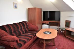 a living room with a red couch and a table at Gościniec Czarci Młyn in Będzin