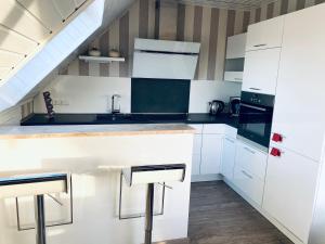 a kitchen with white cabinets and a sink at Ferienwohnung im schönen Westerwald in Müschenbach