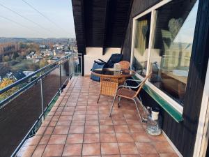 a balcony with a table and chairs on a building at Ferienwohnung im schönen Westerwald in Müschenbach +6 photos