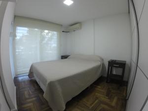 a small bedroom with a bed and a window at Torre Angel - Fragueiro 325 in Córdoba