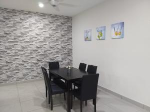 a dining room with a black table and black chairs at Goodview Vacation Homestay @Kajang in Kajang
