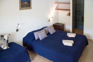 ein Schlafzimmer mit einem blauen Bett mit Handtüchern darauf in der Unterkunft La MAISON du PORT in Port-Cros