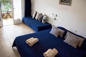 Habitación con 2 camas azules y toallas. en La MAISON du PORT en Port-Cros