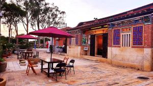 une table et des chaises avec un parasol en face d'un bâtiment dans l'établissement Mount Taiwu Cozy B&B, à Jinhu