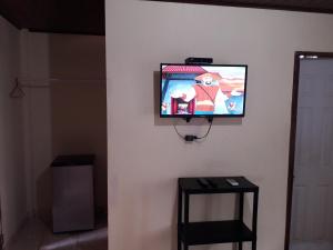 una TV a schermo piatto appesa a un muro di Oceans Hostal a Santa Catalina