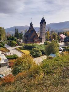 eine Kirche mit einem Uhrturm in einem Garten in der Unterkunft Willa Arte in Karpacz