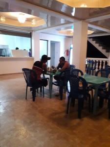 two people sitting at a table in a restaurant at Oceans Hostal in Santa Catalina