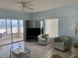 a living room with a television and chairs and a table at Island House Beach Resort 5S in Siesta Key