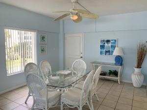 a dining room with a glass table and white chairs at Island House Beach Resort 5S in Siesta Key