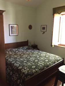 a bedroom with a bed with a comforter and a window at Appartamento di montagna sul Belvedere di Gambarie in Gambarie dʼAspromonte