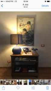 uma mesa com um candeeiro e uma pintura na parede em Pernoicasavacanze em Caprarola