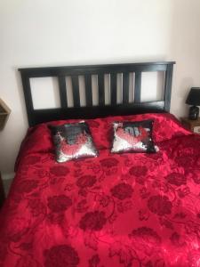 um quarto com uma cama vermelha e 2 almofadas em Pernoicasavacanze em Caprarola