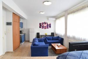 a living room with a blue couch and a table at A Modern Bright Studio In The Center Of Kastoria in Kastoria