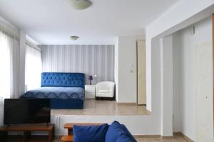 a living room with a blue bed and a couch at A Modern Bright Studio In The Center Of Kastoria in Kastoria