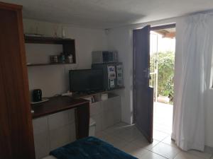 a room with a kitchen with a microwave and a door at Beautiful Sea View Room in Jeffreys Bay