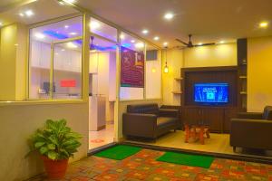 a lobby with a tv and chairs and a table at JK Rooms 126 Parashar Legacy - Opp Railway Station in Nagpur