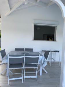 a dining room with a table and chairs and a tv at Les Trésors de Laurëlia in Gourbeyre