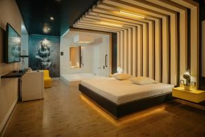 1 dormitorio con 1 cama grande y bañera en Orei Private Suites "Adult Only", en Trujillo