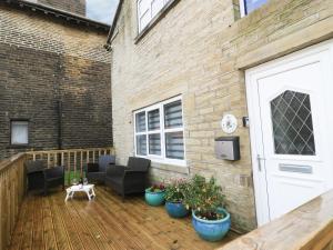 eine Terrasse mit Möbeln und Pflanzen auf einem Backsteingebäude in der Unterkunft The Coach House in Bradford