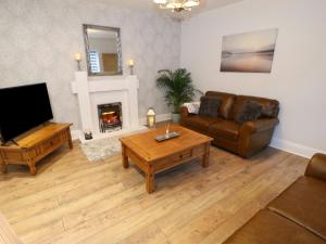 a living room with a couch and a table and a television at The Coach House in Bradford