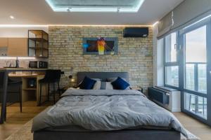 a bedroom with a large bed and a brick wall at VIP - Smart in Kyiv
