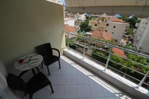 a balcony with a table and chairs and a view at Mona`s apartments 1 in Sarandë +3 photos
