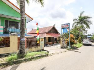 un bâtiment dans une rue avec un palmier et un panneau dans l'établissement OYO 3789 Bukit Somber Residence Syariah, à Kampung Baru