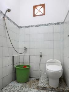 La salle de bains est pourvue de toilettes et d'un seau vert. dans l'établissement OYO 3789 Bukit Somber Residence Syariah, à Kampung Baru
