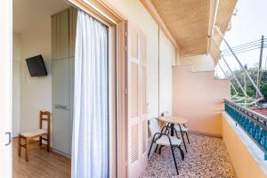 um pequeno quarto com uma mesa e cadeiras e uma janela em Lefktron Hotel em Stoupa