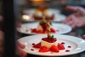 a person holding a plate with a dessert with strawberries at The Brisley Bell in Brisley