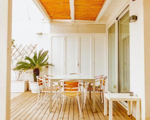 uma sala de jantar com uma mesa e cadeiras brancas em Interno 3 em Bari