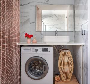 a bathroom with a washing machine and a sink at Sia Mare Seaside Apartments in Faliraki