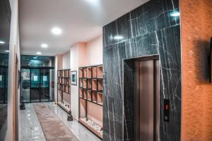 a hallway with a door and shelves of books at Hotel DOA in Skopje