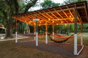 VILLA DO SOSSEGO pousada في ليندويا: أرجوحة تحت جناح خشبي في حديقة