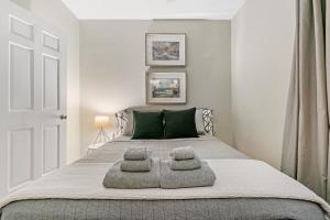 1 dormitorio con 1 cama con 2 almohadas en Trendy 2BR Apartment with Modern Amenities - Halsted 2A, en Chicago