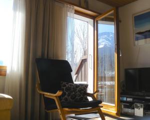 a living room with a chair and a television at Viosia-Ost in Fiesch