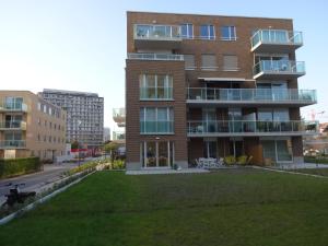 un edificio de apartamentos con césped delante en Bootsman gelijkvloers appartement met tuin en autostaanplaats en Ostende