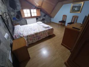 a bedroom with a bed, chair and a window at Hotel Rural Camino Medulas in Ponferrada