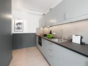 una cocina con armarios blancos y fregadero en LivinParis - Luxury 3 Bedrooms Opera II, en París