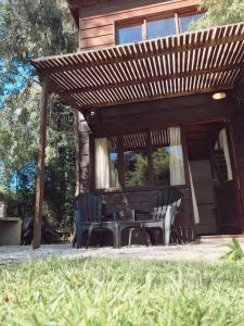 une terrasse avec une table et des chaises devant une maison dans l'établissement Cabañas Aire Fresco, à Mar del Plata