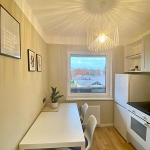 a kitchen with a white table and a window at Mokka Room in Valmiera