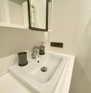 a white sink in a bathroom with a mirror at Mokka Room in Valmiera +9 photos