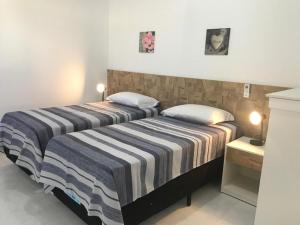 two beds sitting next to each other in a bedroom at Casa Porto Fiore in Paripueira