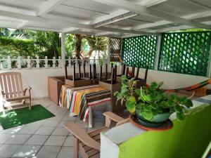 une terrasse avec une table, des chaises et une plante dans l'établissement Le Jardin de Massieux, à Bouillante