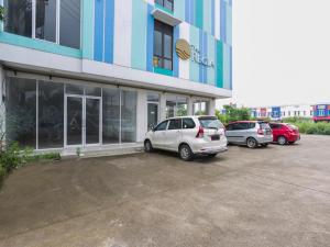 three cars parked in a parking lot in front of a building at Super OYO Flagship 3486 The Regia Tambun by Ultimo in Bekasi