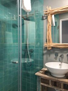 a bathroom with a sink and a glass shower at Casa da Praça Guest House in Sesimbra