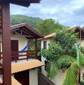un edificio con un balcón con árboles y una montaña en Pousada Familia Quandt, en Guarda do Embaú